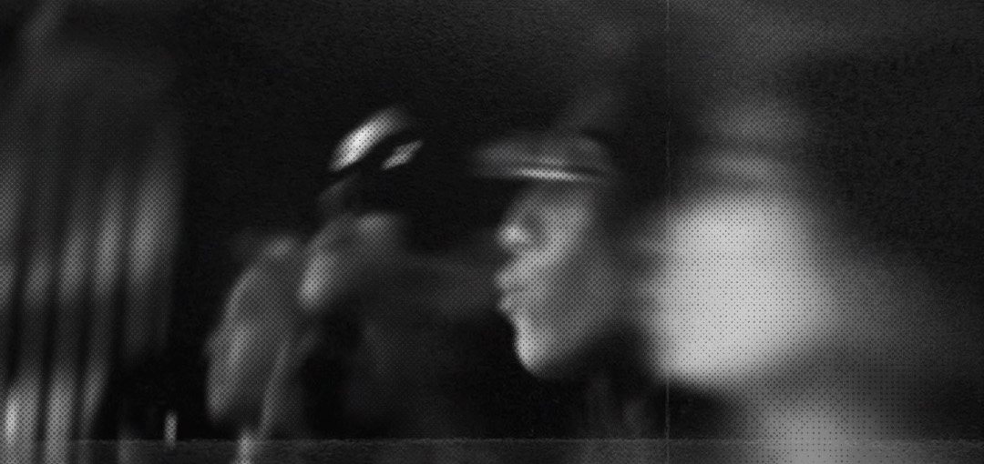 Blurred black and white photo of people dancing at a club night.